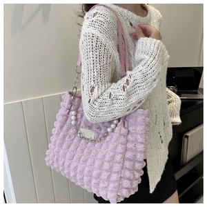 Détail du sac cabas rose avec poignée en perles et texture gaufrée sophistiquée