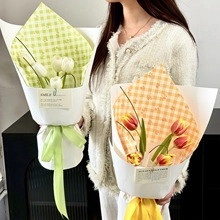Detail of faux tulip bouquets in green and orange with double-layered plaid wrapping paper
