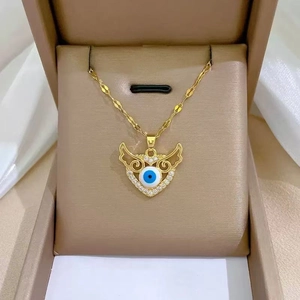 Detailed close-up of golden evil eye heart pendant with sparkling cubic zirconia inlay