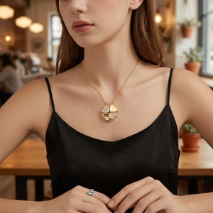 Golden magnetic folding heart clover necklace with white cubic zirconia worn by model
