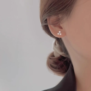 Three-pearl clover cluster stud earrings for women shown on model for elegant look