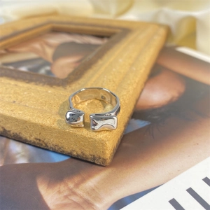 Irregular lava texture open ring in silver finish placed on vintage wooden frame background