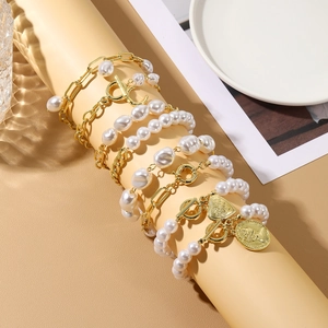 Baroque pearl and gold chain layered bracelet set with heart and coin charms