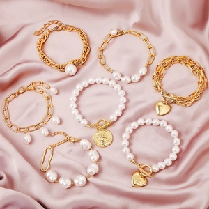 Set of seven vintage Baroque pearl bracelets with golden alloy chains and coin charms
