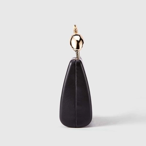 Detail view of smooth black PU leather evening clutch with artistic gold ball metal clasp