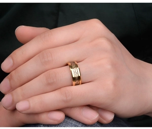 Close-up of gold titanium steel ring featuring an intricate black Celtic dragon inlay pattern