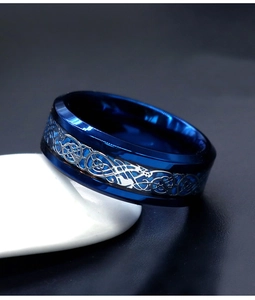 Detail of blue titanium steel ring with silver Celtic dragon pattern inlay for men