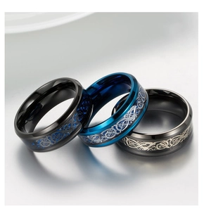 Detail view of titanium steel rings with Celtic dragon inlay in black, blue and silver finishes
