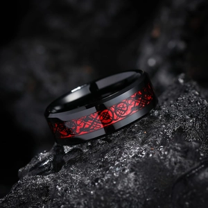 Macro shot of men's black stainless steel ring with red dragon inlay on dark stones