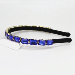 Close-up of elegant headband featuring sparkling blue crystal rhinestones with golden claw settings