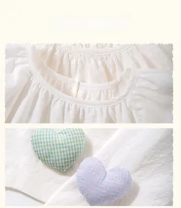 Detail of cream cotton-linen top featuring pleated collar and checkered heart embroidery