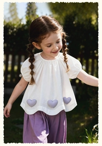 Detail of girl's summer set featuring heart-shaped appliques and purple wide-leg pants