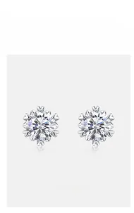 Close-up of snowflake-shaped sterling silver stud earrings set with sparkling moissanite