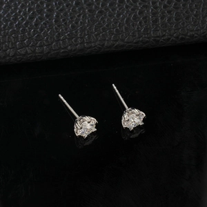 Macro view showing classic six-prong setting detail of a sparkling silver moissanite stud