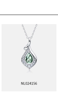 Macro shot of silver teardrop moss agate pendant with halo of white accent stones