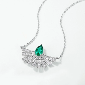 Elegant silver fan-shaped necklace featuring a pear-cut emerald gemstone on a plain background