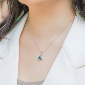 Elegant S925 silver necklace with four-leaf clover emerald pendant on female model