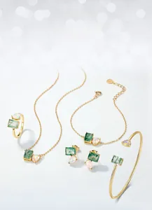 Detail of gold jewelry set with green moss agate and iridescent opal stones