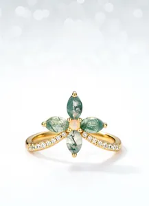 Detail of gold four-leaf clover ring with green moss agate petals and opal center