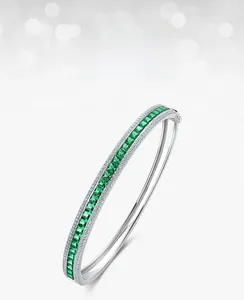 Detailed macro view of silver bangle with rectangle emerald and pavé-set white zircons