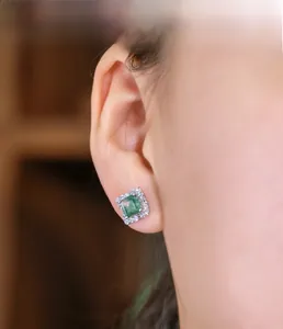 Macro shot of square emerald agate earrings with sparkling pavé crystal halo on ear