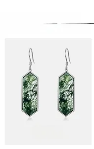 Detailed macro view of S925 silver earrings with hexagonal green moss agate stones