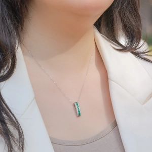 S925 sterling silver necklace with emerald cut pendant and small white stones on a woman