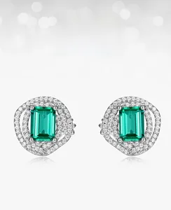 Close-up of emerald cut green gemstone earrings with sparkling white cubic zirconia pavé