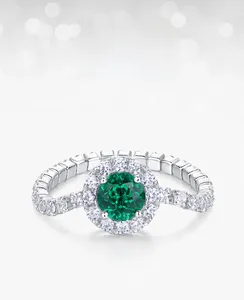 Macro view of a halo S925 silver ring featuring a round emerald and white cubic zirconia