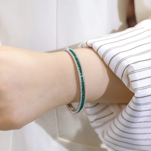 Elegant S925 sterling silver bangle with emerald stones and diamond accents on wrist