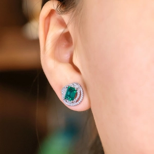 Square emerald cut silver stud earrings with asymmetrical diamond halo design