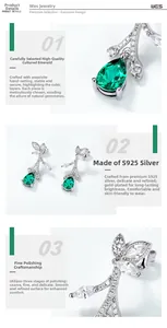 Detail view of S925 sterling silver leaf earrings with pear-cut lab emerald gems