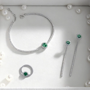 S925 silver jewelry set with emerald gemstones and white zircons on white velvet