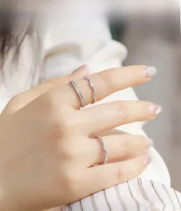 Close-up of three stacked S925 sterling silver rings with shimmering moissanite stones