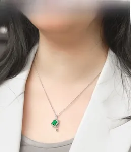 Detail view of S925 silver emerald pendant necklace with halo crystals on a model