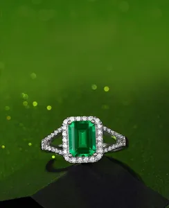 Macro shot of 1.25ct emerald cut green gemstone ring with pavé diamond halo and split shank