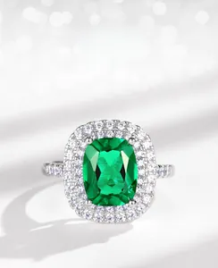 Macro shot of cushion-cut lab emerald ring with double halo setting in silver finish