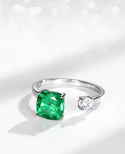 Detailed view of silver ring featuring square emerald stone and round white zircon