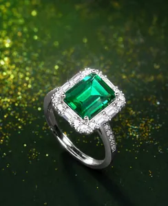 Macro de un anillo de esmeralda rectangular con pequeños diamantes en banda de plata