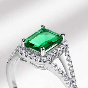 Classic S925 silver ring with a 1.25ct emerald cut green gemstone and halo diamonds
