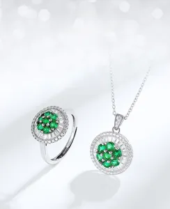 Detailed macro view of S925 silver necklace and ring set with emerald floral pendants