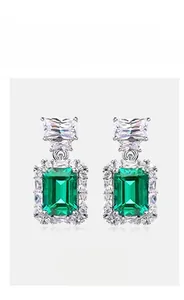 Detail view of emerald-cut green crystal earrings with sterling silver halo setting