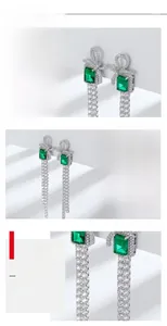 Macro detail of S925 silver bow earrings with emerald stones and diamond tassels
