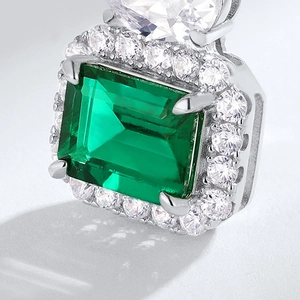 Pendentif luxueux avec émeraude rectangulaire et halo de diamants sur chaîne