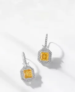 Vue macro de boucles d'oreilles carrées en diamant jaune et argent S925 avec halo