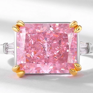 Luxurious pink radiant cut ring with baguette side stones and gold claws in close-up