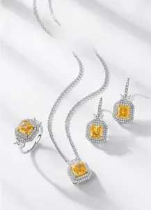 Gros plan d'un ensemble de bijoux en argent avec pierres jaunes taille radiant et halo