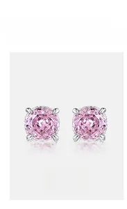 Close-up of pink high carbon diamond stud earrings in a four-prong silver setting