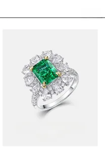 Macro detail of emerald-cut green gemstone ring with sparkling flower halo setting