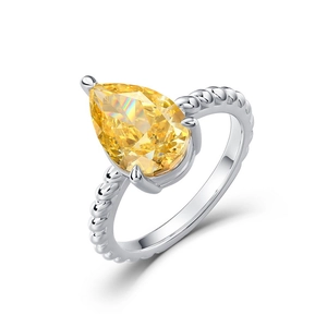 Pear cut yellow gemstone ring with twisted silver band texture on white background